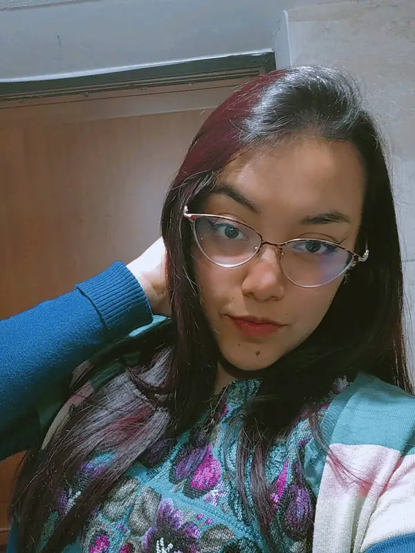 Woman with dark red hair and thin glasses