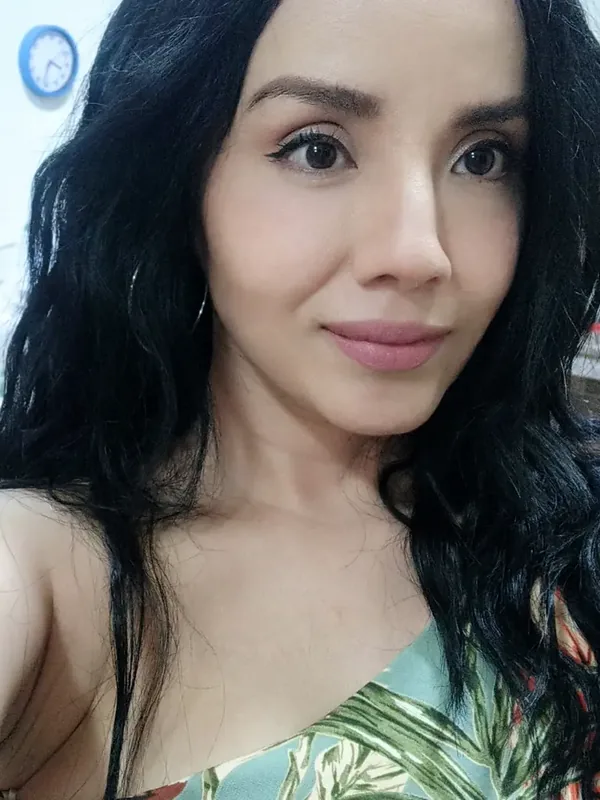 Woman with long dark hair smiling at the camera